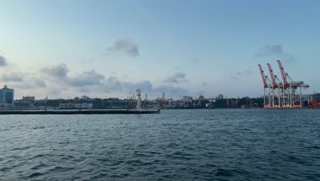 harbour cranes at port of odesa from a boat crossing at calm waves of black sea in ukraine