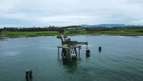 Industrial structure protruding out to the ocean with an abandon coal mine in the foreground