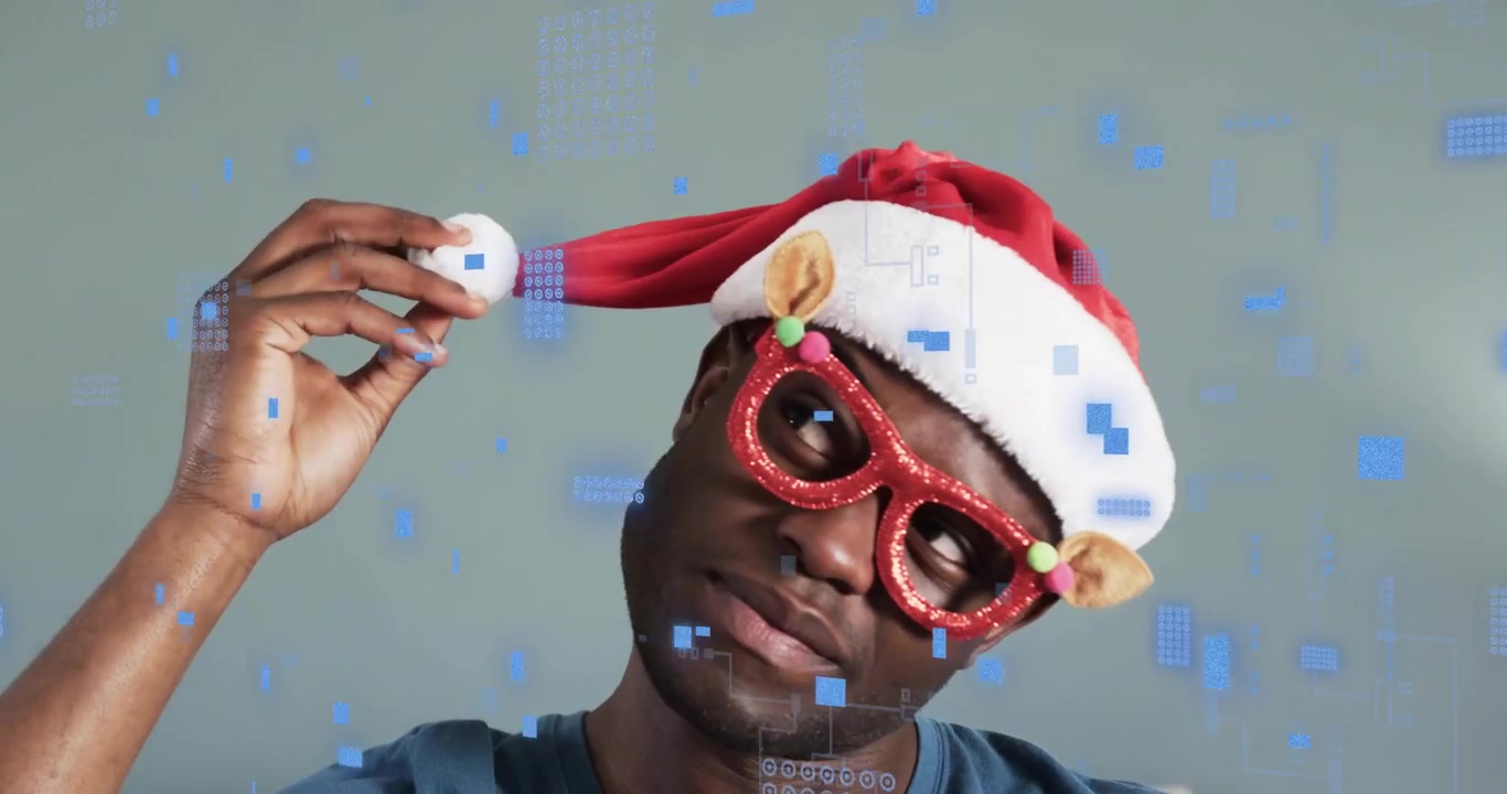Uomo con camicia blu che alza le mani aggiustandosi il cappello di Babbo Natale per il marketing natalizio con sovrapposizione di circuiti.
