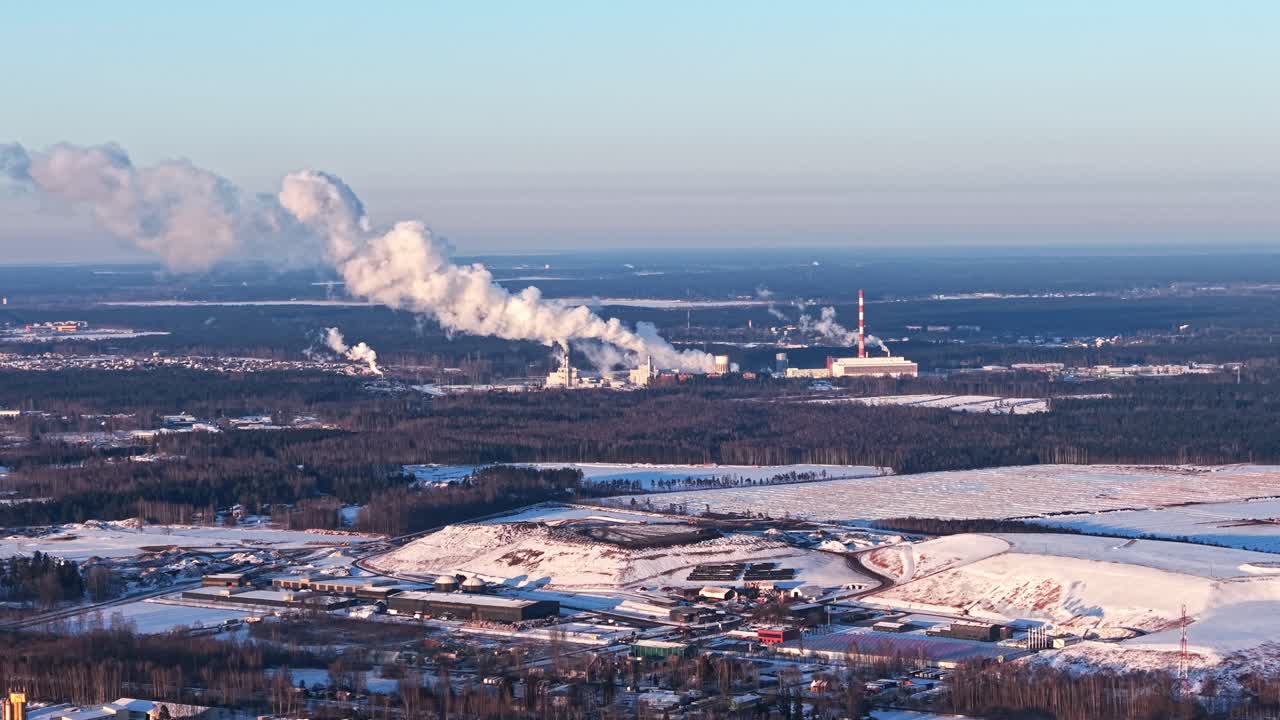 Thermal power station emitting steam across a snow covered industrial landscape, data center pollution in forest