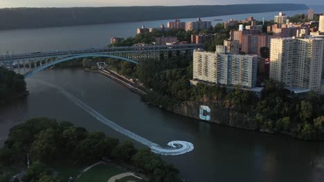 Vista-Aérea-De-Un-Hotdogging-En-Moto-Acuática-A-Través-De-Spuyten-Duyvil-Debajo-Del-Puente-Henry-Hudson-En-La-Ciudad-De-Nueva-York