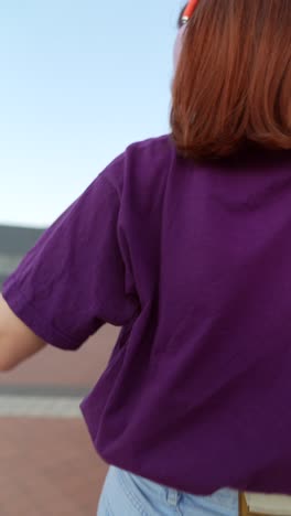 woman dancing outdoors with headphones