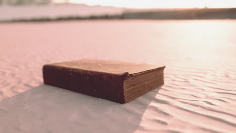 old book on the sand beach