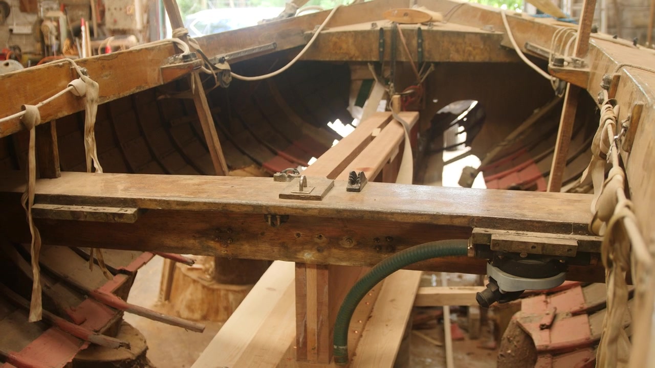 Interno di una tradizionale barca a vela in legno a fasciame sovrapposto in riparazione da parte di un maestro d'ascia