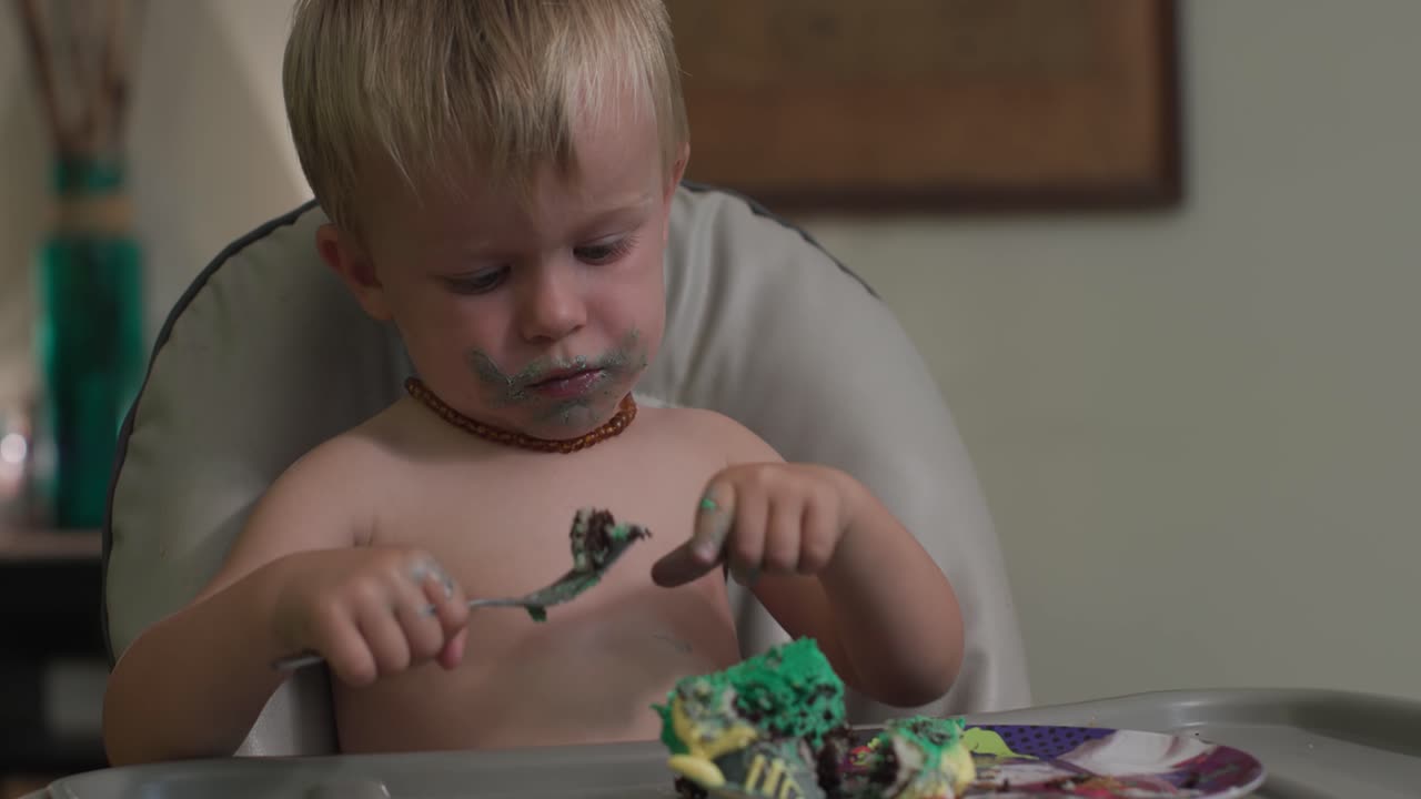 Toddler Boy Enjoying a Messy Birthday Cake
