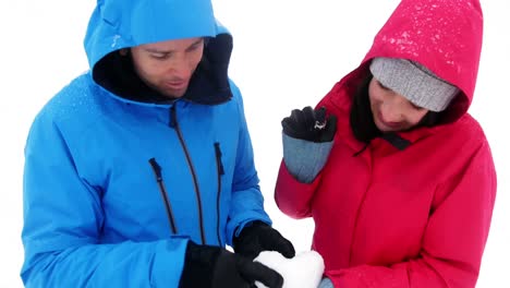 Happy-couple-making-snow-heart