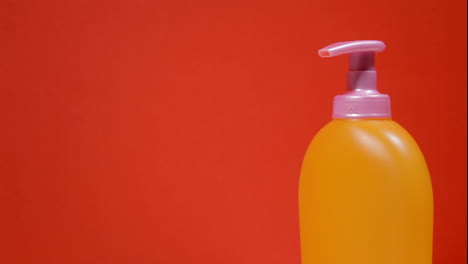 an orange soap dispenser plastic bottle on a rotating surface