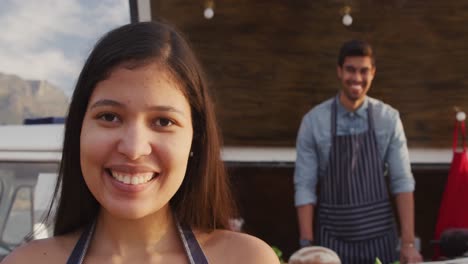 Young-couple-looking-at-the-camera-at-food-truck