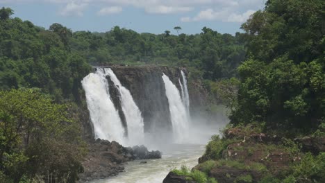 Cataratas-Del-Iguazú-En-Brasil,-Espectacular-Vista-Lejana-De-Hermosas-Cascadas-En-Un-Pintoresco-Paisaje-Verde-Selvático,-Increíble-Agua-Cayendo-De-Enormes-Acantilados-En-Hermosas-Condiciones-Soleadas