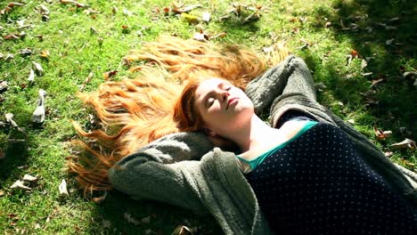 Young-redhead-relaxing-on-lawn