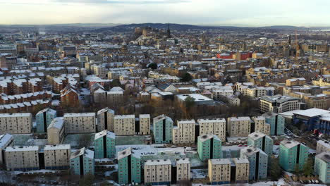 Toma-Aérea-De-La-Ciudad-De-Edimburgo-Y-El-Castillo-En-Invierno-Con-Pisos-Altos-En-Primer-Plano