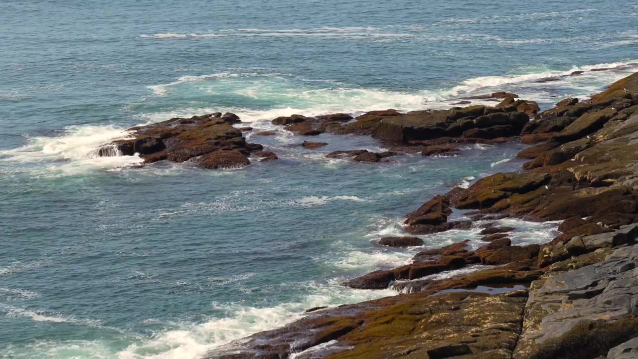 Ondas do oceano rolando em direção à costa rochosa no litoral do Maine