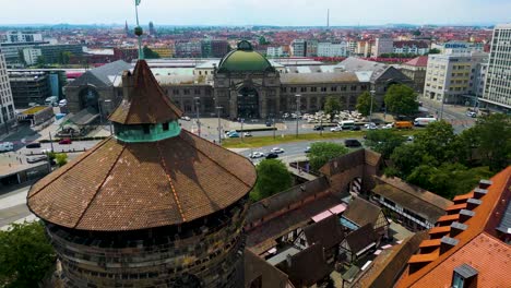 4k aerial drone video of ancient women's gate tower and hauptbahnhof train station in downtown nurnberg, germany