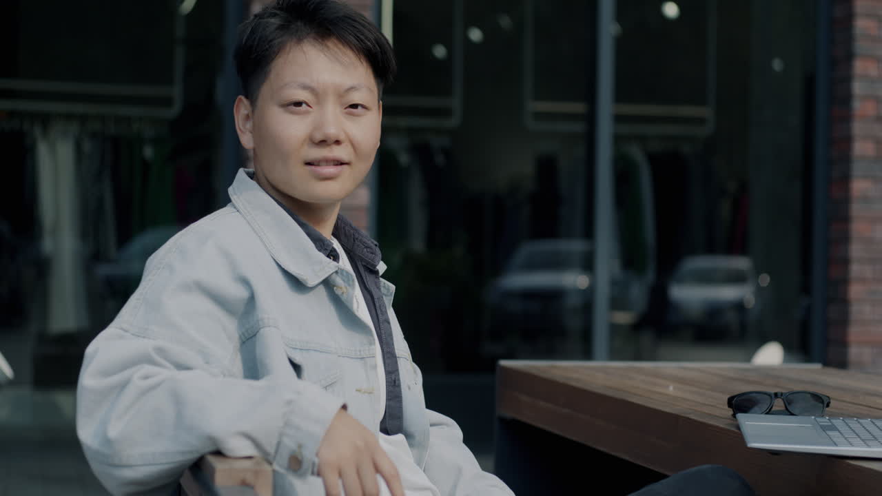 Young Man Sitting Outdoors with Laptop