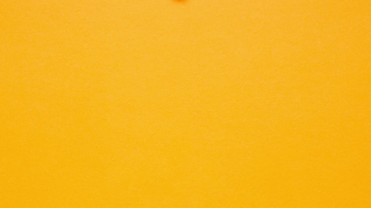 Blue crumpled paper unfolds on orange in a stop motion transition