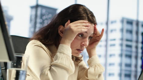 Stressed woman entrepreneur suffering form a migraine from workload and fatigue