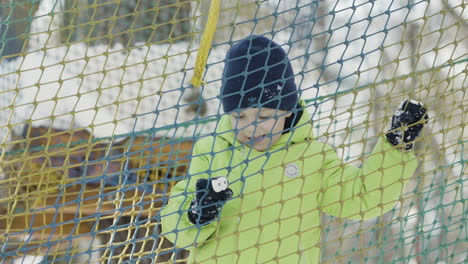 child playing on a snowy net structure