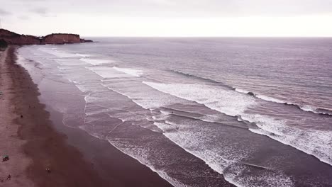 Die-Atemberaubende-Landschaft-Eines-Ruhigen-Meeres,-Das-Am-Strand-Von-Olon-Ins-Ufer-Plätschert-–-Luftaufnahme