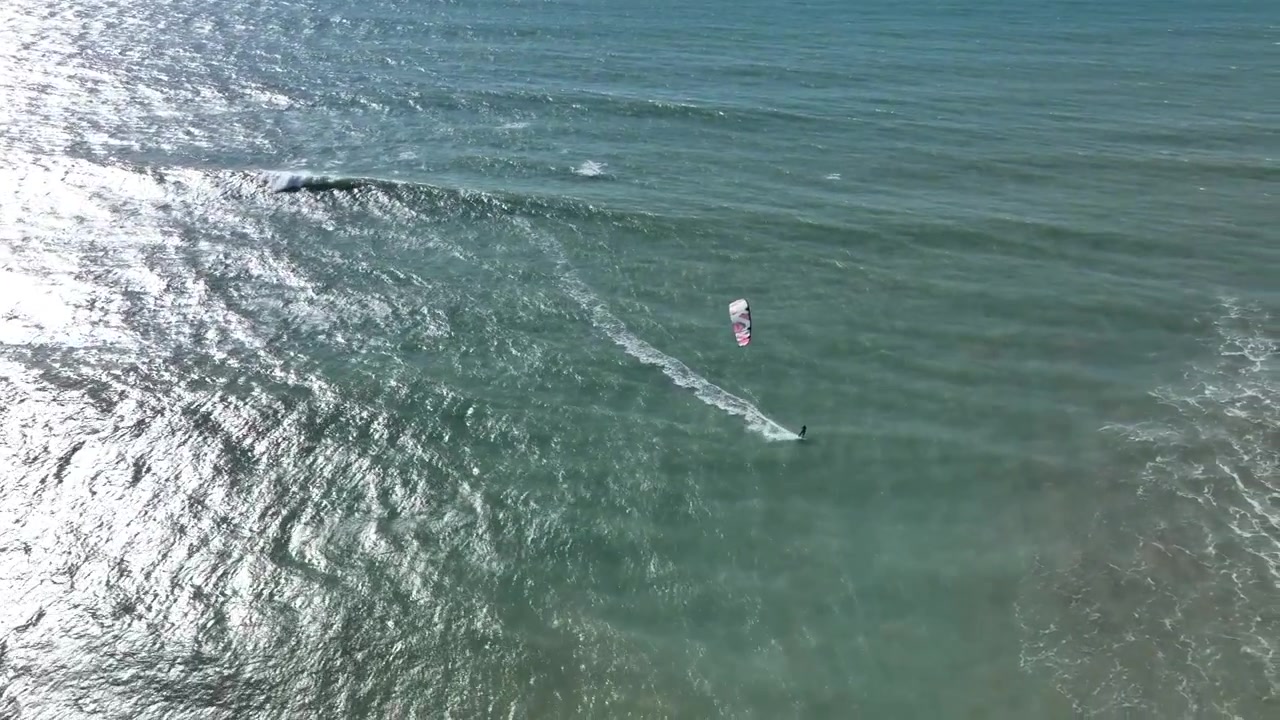 Vista aérea de dron de un practicante de wing foil deslizándose por el Océano Atlántico cerca de Dakhla, Marruecos, mostrando uno de los principales destinos del mundo para deportes acuáticos impulsados por el viento