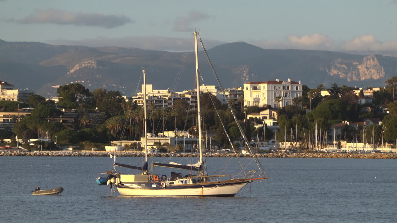 Antibes, Francia - 21 marzo 2025: Barca ormeggiata sul mare con la città sullo sfondo