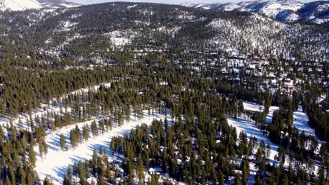 A-beautiful-aerial-drone-shot,-flying-over-the-woods-towards-the-mountains-in-Lake-Tahoe,-Nevada-California