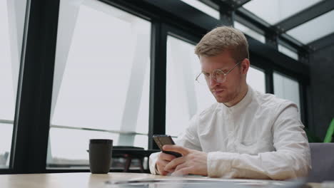 uso patológico de internet y el apocalipsis de la gente moderna hombre europeo guapo está leyendo noticias en el teléfono inteligente
