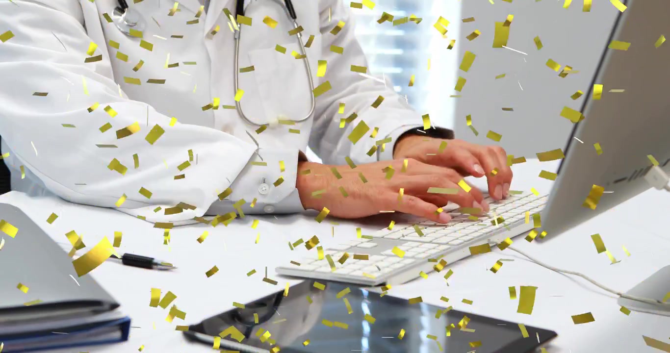 Doctor revisando expedientes y escribiendo para documentar notas, con el teclado visible y confeti dorado superpuesto