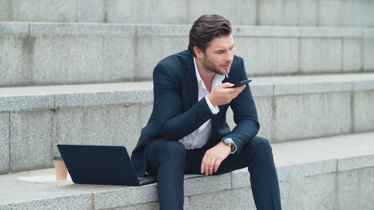 Handsome businessman recording voice message