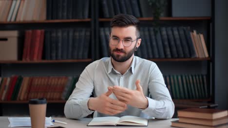 hispanic male blogger shooting video talking explaining business education news at library desk