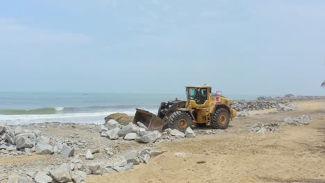 construcción de defensas marítimas con tractor de máquina cargadora