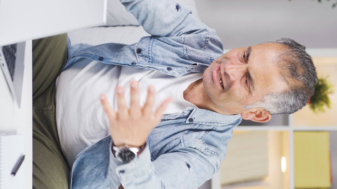 vídeo vertical del hombre que se enojó por lo que vio en la computadora portátil.