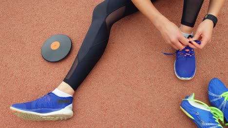 low section of female athlete tying shoelaces at sport venue 4k