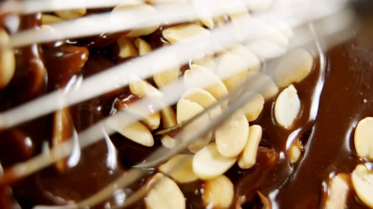 Peanuts being mixed in melted chocolate 4k