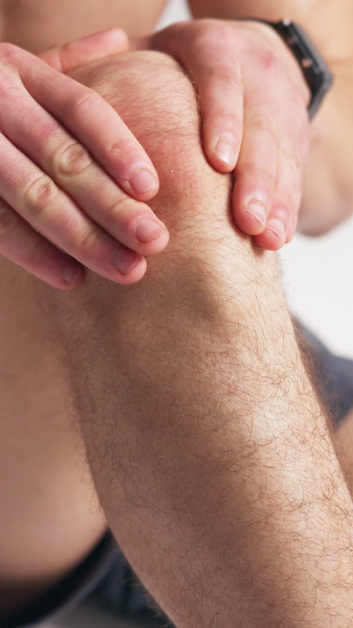 Primer plano de manos masajeando una rodilla dolorosa