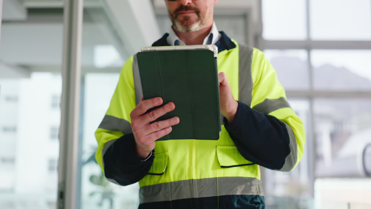 Man in high visibility jacket using tablet