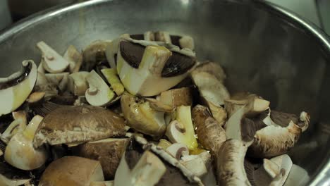 pouring olive oil ob fresh champignon mushrooms in frying pan, close up