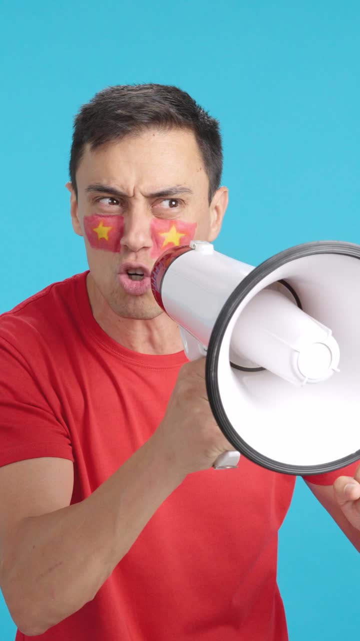 Excited man with vietnamese flag on face using a megaphone
