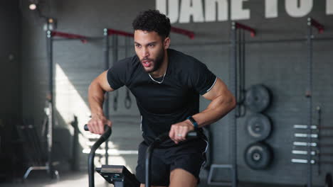 hombre haciendo un entrenamiento intenso en una máquina de ciclismo en el gimnasio