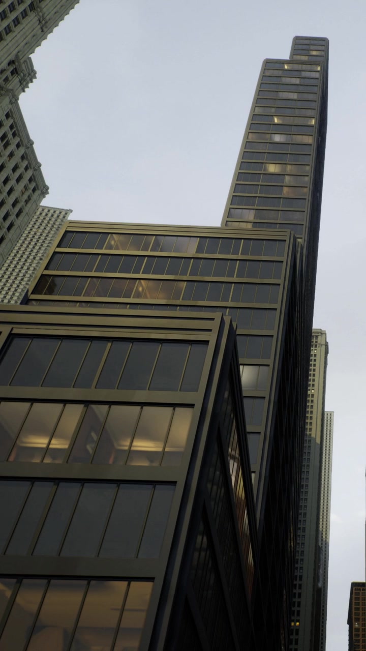 Vista de un edificio alto rodeado de otros edificios en una ciudad al anochecer.