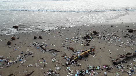 toma en cámara lenta mientras las olas arrastran basura del océano, basura en la playa