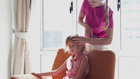 madre peinando el cabello de su hija