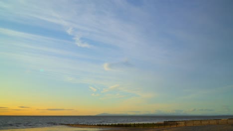 High-altitude-clouds-sweeping-across-the-shoreline-at-sunset