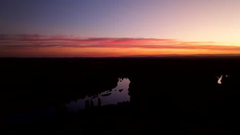river silhouette under orange dusk in chile - drone shot
