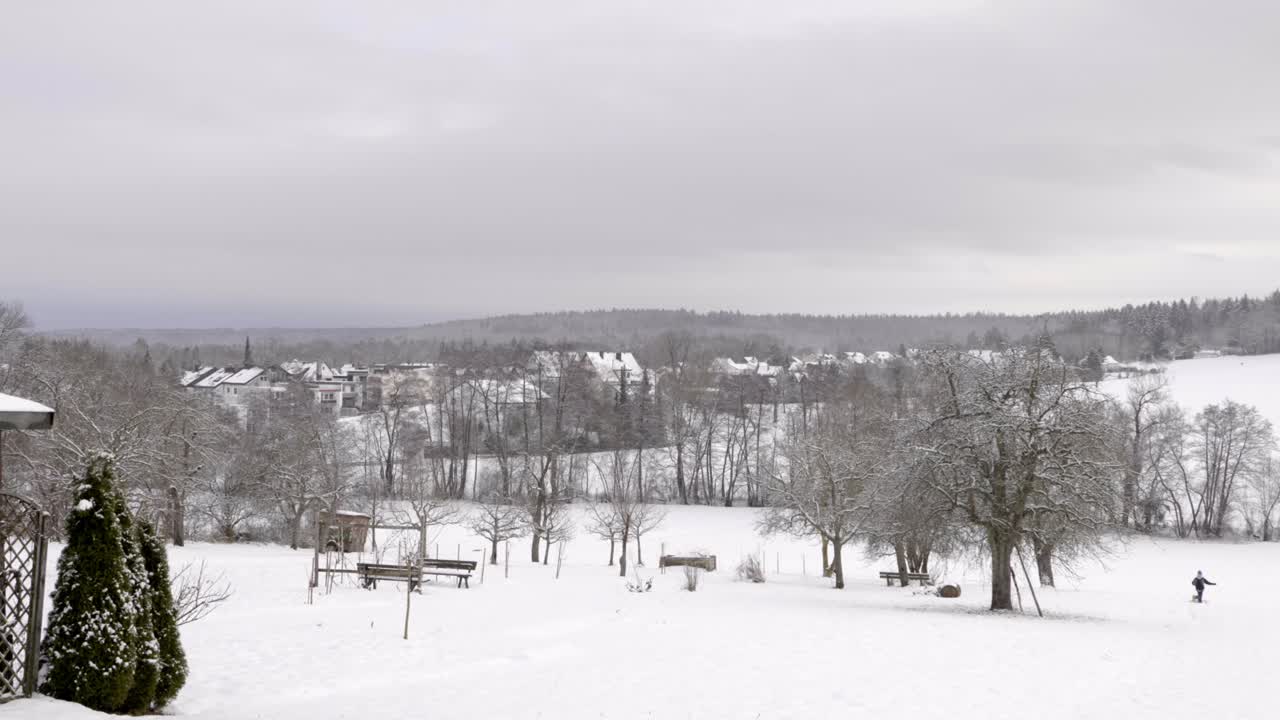 밝은 눈이 내린 날, 4k에서 멀리 매를 행복하게 끌고 있는 어린 아이