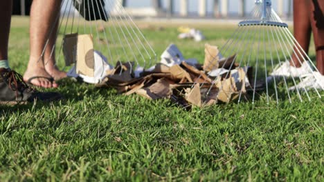 people gathering garbage with rakes