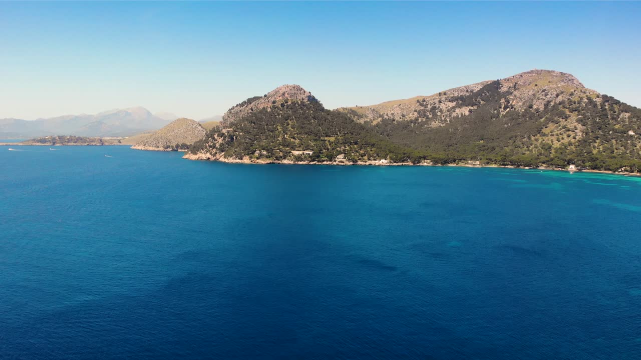 Drone over scenic cerulean waters of Mediterranean towards rugged Majorca, Spain