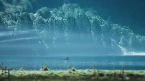 a fisherman in the boat on the lake