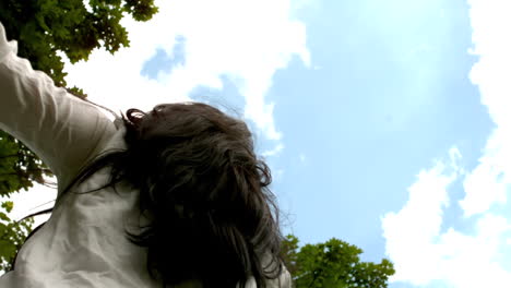 una morena despreocupada girando en el parque