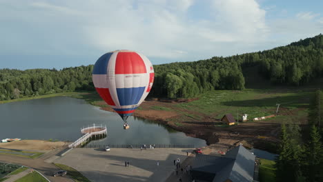 globo de aire caliente sobre un lago en un bosque