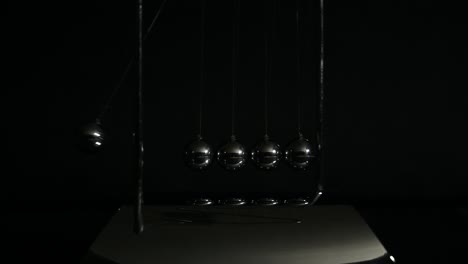 newtons cradle balancing balls in dark tone. movement physics and common physical laws concept for action and reaction, cause and effect. balls newton.